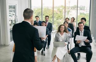 grupo de personas que escuchan a profesionales de negocios experimentados que los ayudan a elaborar una nueva estrategia corporativa.