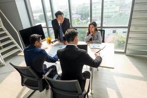 Business professionals. Group of young confident business people analyzing data using computer while spending time in the office photo