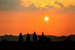 silhouette Cowboy on horseback against a beautiful sunset, cowboy and horse at first light, mountain, river and lifestyle with natural light background