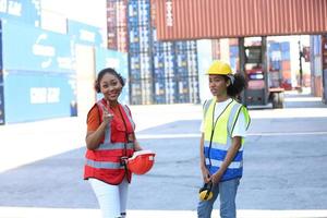Foreman control loading Containers box from Cargo freight ship for import export. photo