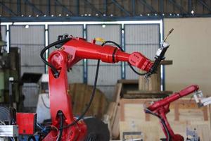 Robotics arm in the metal factory plant . it's performing routine servicing of the welding robotics units equipment. photo