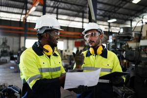 Maintenance Engineers is working in front of the automated CNC machinery repair on a maintenance checklist at the production line. photo