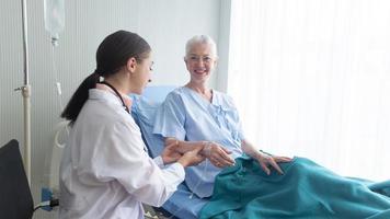 Female doctor and elderly patient check up in hospital. photo