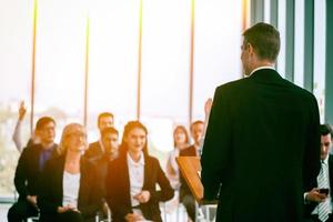 Group of people listening to experienced business professional helping them work out new corporate strategy. photo