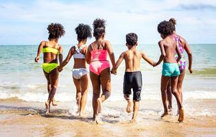 Kids playing running on sand at the beach photo