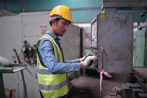 Maintenance Engineers is working in front of the automated CNC machinery repair on a maintenance checklist at the production line. photo