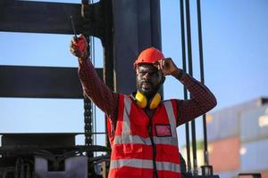 Engineer or supervisor checking and control loading Containers box from Cargo at harbor. Foreman control Industrial Container Cargo freight ship at industry. Transportation and logistic concept. photo