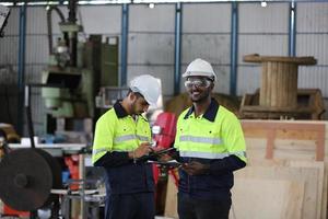 Maintenance Engineers is working in front of the automated CNC machinery repair on a maintenance checklist at the production line. photo