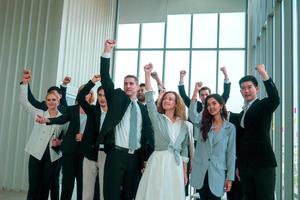 Successful business people standing together widen out showing strong relationship of worker community. A team of businessman and businesswoman expressing a strong group teamwork at the modern office.