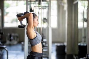 mujer joven haciendo ejercicio en el gimnasio. fuerte atleta femenina haciendo ejercicio. foto