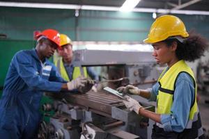 Maintenance Engineers is working in front of the automated CNC machinery repair on a maintenance checklist at the production line. photo