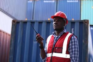 Engineer or supervisor checking and control loading Containers box from Cargo at harbor. Foreman control Industrial Container Cargo freight ship at industry. Transportation and logistic concept. photo