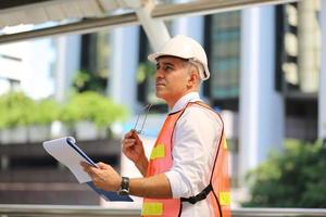 The engineer and business woman checking on clipboard at construction site building. The concept of engineering, construction, city life and future. photo