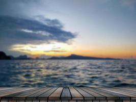 mesa de madera vacía en una hermosa puesta de sol borrosa foto