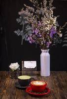 Hot cappuccino coffee in red cup and green tea with saucer on wooden table, view for relaxing and input text. photo