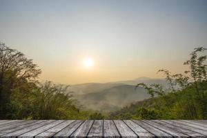 mesa de madera y desenfoque de belleza, cielo al atardecer y montañas como fondo. foto