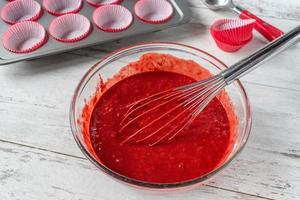 red velvet cake batter with ingredients and cupcake tin photo