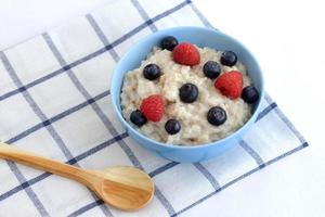 Healthy breakfast on the table. Food for a healthy diet. Porridge with berries view from above on a light background photo