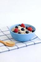 Healthy breakfast on the table. Food for a healthy diet. Porridge with berries view from above on a light background photo