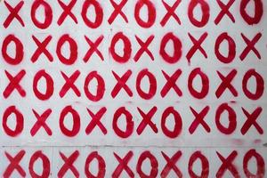 Red hand written doodle XO XO on white wall background, Hugs and kisses pattern. Love relationship in Valentines Day photo