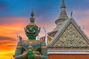 gigantes frente a la iglesia en el templo de wat arun. wat arun es uno de los monumentos más conocidos de tailandia. wat arun es un templo budista en el distrito de bangkok yai de bangkok, tailandia. foto