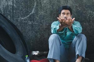 A man sitting by a wall photo