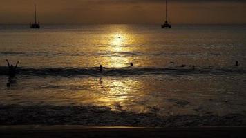 prachtige zonsondergang met silhouetten van mensen genieten van de oceaan.