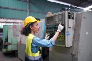 las ingenieras de mantenimiento están trabajando frente a la reparación automatizada de maquinaria cnc en una lista de verificación de mantenimiento en la línea de producción. foto