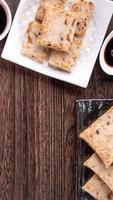 Delicious turnip cake, Chinese traditional local radish cake in restaurant with soy sauce and chopsticks, close up, copy space, top view, flat lay. photo