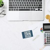 Online payment with QR code concept, virtual credit card, smart phone on office laptop desk on clean marble table background, top view, flat lay photo