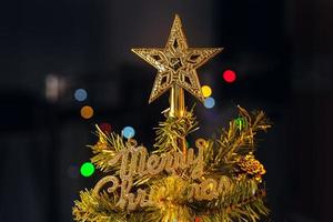 Beautiful Christmas decor concept, bauble hanging on the Christmas tree with sparkling light spot, blurry dark black background, macro detail, close up. photo