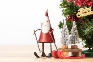 Decorated cute Christmas tree on a wooden floor with white background and toys, blank for festive design concept, close up. photo