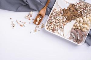 Ingredients of Four Tonics Soup, Four Herb Flavor Soup. Taiwanese traditional food with Job's tears, herbs, pork intestines on white background photo