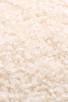 cultivo de arroz comestible molido pulido blanco crudo sobre fondo blanco en tazón marrón, concepto de diseño de agricultura orgánica. alimento básico de asia, de cerca. foto