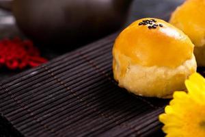 sabroso pastel de luna de yema de huevo horneado para el festival de mediados de otoño sobre fondo oscuro de pizarra negra. concepto de comida festiva china, primer plano, espacio de copia. foto