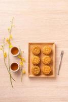 Mid-Autumn Festival holiday concept design of moon cake, mooncakes, tea set on bright wooden table with copy space, top view, flat lay, overhead shot photo