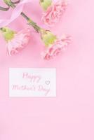 hermoso, fresco y elegante ramo de flores de clavel con saludo blanco gracias tarjeta de regalo aislada sobre fondo de color rosa brillante, vista superior, concepto plano. foto
