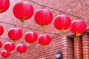 Beautiful round red lantern hanging on old traditional street, concept of Chinese lunar new year festival, close up. The undering word means blessing. photo