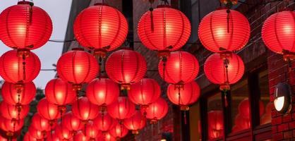 Beautiful round red lantern hanging on old traditional street, concept of Chinese lunar new year festival, close up. The undering word means blessing. photo