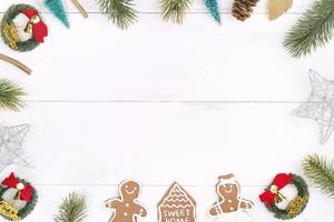 objetos de decoración de composición de concepto de navidad, corona de rama de abeto, galleta de hombre de pan de jengibre aislada en una mesa de madera blanca, vista superior, capa plana