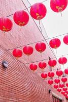 Beautiful round red lantern hanging on old traditional street, concept of Chinese lunar new year festival, close up. The undering word means blessing. photo