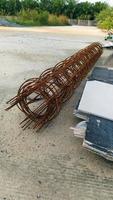 Long rolls of rusted wire mesh on the gravel floor. photo