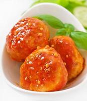 meatballs in tomato sauce, decorated with leaves of basil photo