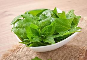 washed spinach leaves in a bowl on a wooden table photo
