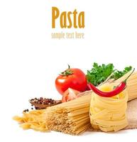 espaguetis de pasta, verduras, especias aisladas en blanco foto