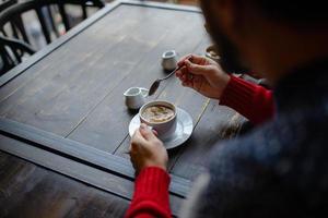 Couple holding knitted coffee cups dressed in sweater photo