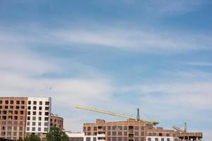 Crane and building construction site against blue sky photo