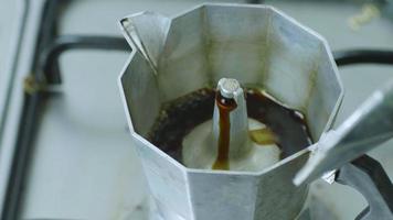 el proceso de montaje y elaboración de café recién hecho con cafetera moka. hacer café recién hecho en la estufa de gas en la cocina de casa. video