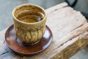 una taza de té caliente en la mesa de madera. foto