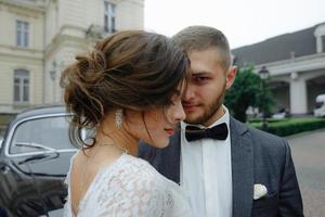 hermosa novia hermosa y elegante novio guapo, pareja rústica en un campo de girasoles besándose foto